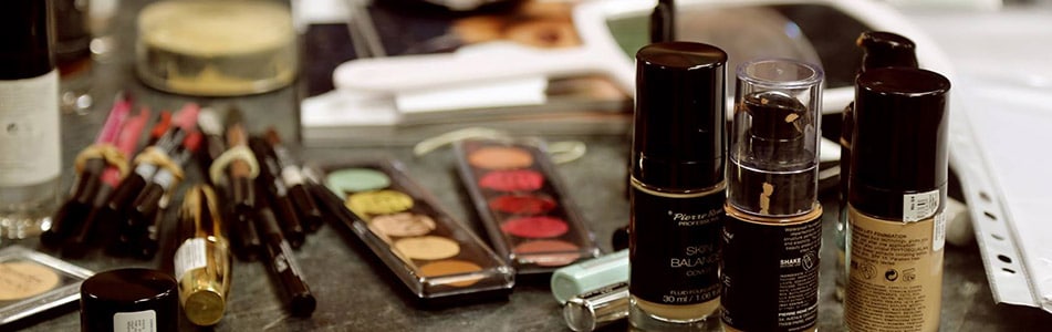 Makeup scattered on desk.